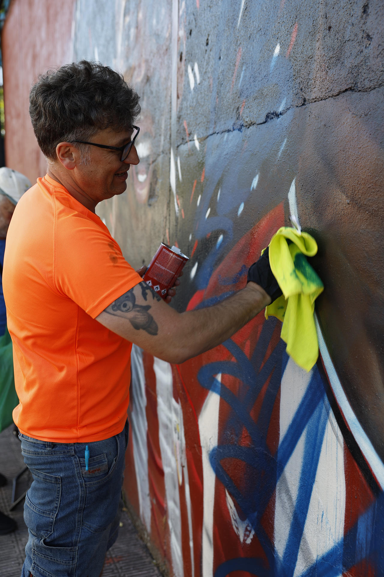 El mural con la imagen de Nico Williams en Barakaldo que había sido atacado el pasado fin de semana ha vuelto a ser vandalizado la pasada madrugada unas horas después de que el autor, el artista Carlos López (en la imagen), hubiese iniciado en la jornada del viernes los trabajos de restauración.
La figura de Nico ha sido emborronada con pintura azul y a su lado ha aparecido escrito 'rata de mierda', insulto que el propio López ha borrado nada más regresar al muro en la mañana del sábado para retomar su labor en el muro exterior de una parcela del barrio de Lutxana. Posteriormente ha continuado limpiando el resto de la pintura lanzada con spray con relativa facilidad mediante un trapo empapado en disolvente. EFE/ Miguel Toña