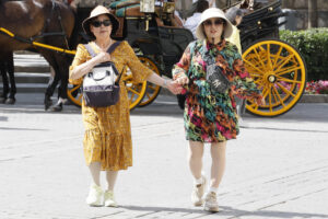 Turistas se tapan con sombreros mientras caminan por el centro histórico de Sevilla, este martes. EFE/José Manuel Vidal