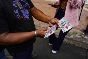 Fotografía cedida por las Fuerzas Armadas de Ecuador de una persona sosteniendo billetes falsos de 100 dólares que fueron lanzados desde un helicóptero con información sobre el plan de recompensas que se implementa a nivel nacional para incentivar las denuncias contra miembros de redes criminales o escondites de armas y drogas este viernes, en Guayaquil (Ecuador). EFE/ EFE/ Fuerzas Armadas De Ecuador
