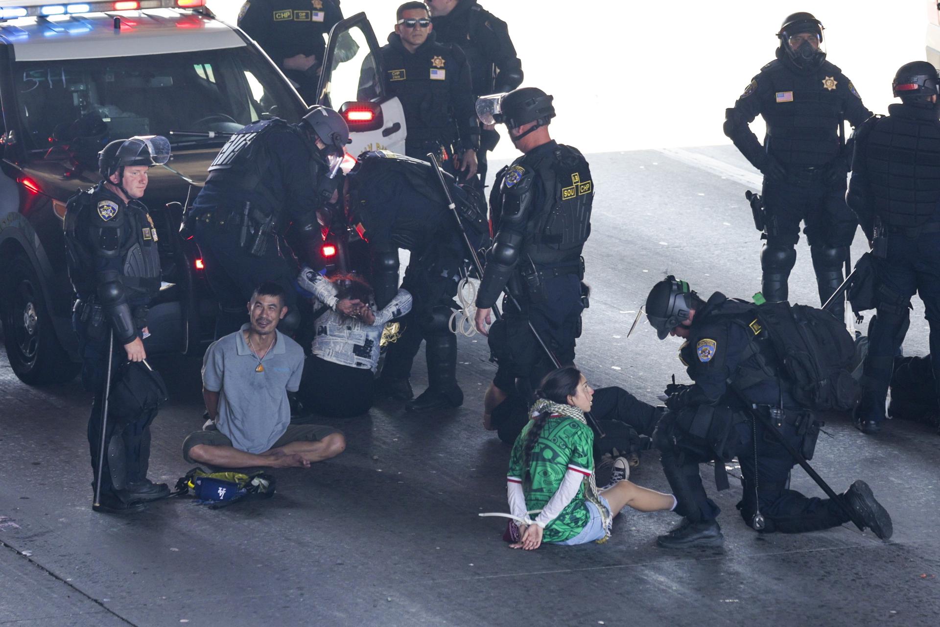 Un grupo de agentes de policía de Los Ángeles fue captado este domingo, 8 de junio, al arrestar a varios ciudadanos que protestaban contra las redadas de inmigración y detenían el tráfico en la autopista 101, cerca del edificio federal Edward R. Roybal, en Los Ángeles (CA, EE.UU.). EFE/Allison Dinner