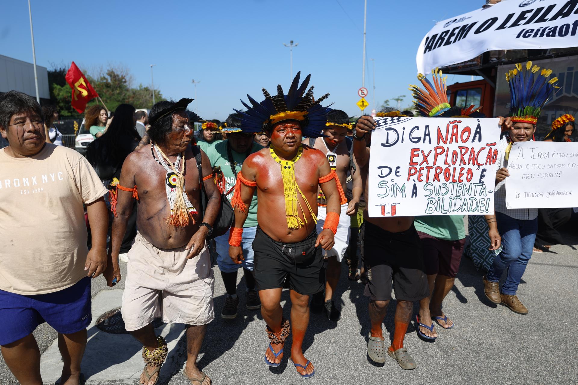 AME6601. RÍO DE JANEIRO (BRASIL), 17/06/2025.- Indígenas participan en una protesta este martes, en Río de Janeiro (Brasil). Unos cien manifestantes, entre indígenas, ecologistas y sindicalistas, protestaron este martes contra la subasta promovida por Brasil para ofrecer concesiones con el fin de explorar y explotar áreas en una vulnerable región marina próxima a la desembocadura del Amazonas. EFE/ Antonio Lacerda