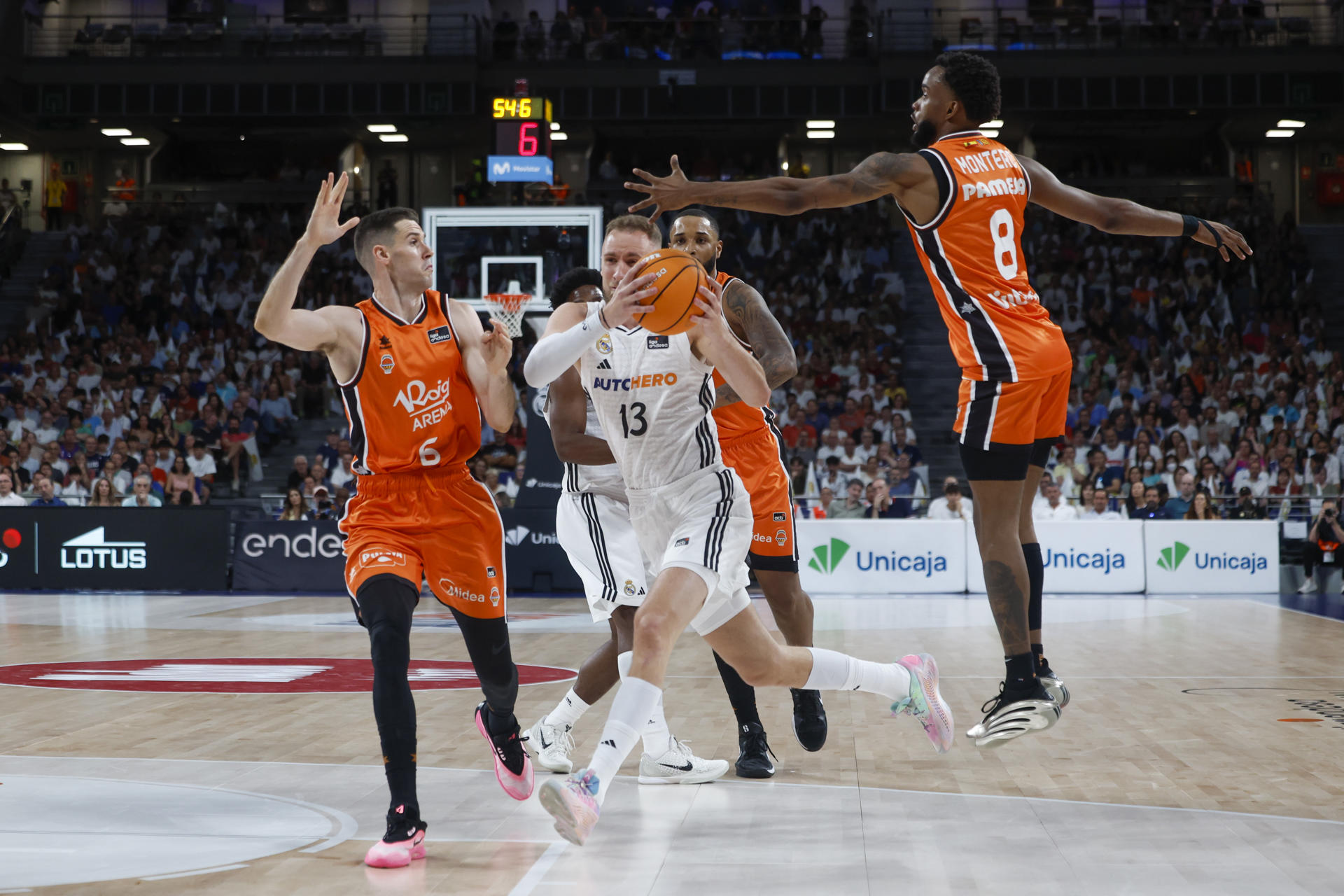 El alero bosnio del Real Madrid Dzanan Musa (c) entra a canasta defendido por Jean Montero (d) y López-Aróstegui (i), ambos del Valencia Basket, durante el primer partido de la final de la Liga Endesa de baloncesto entre el Real Madrid y el Valencia Basket, en el Movistar Arena, en Madrid. EFE/ Juanjo Martín
