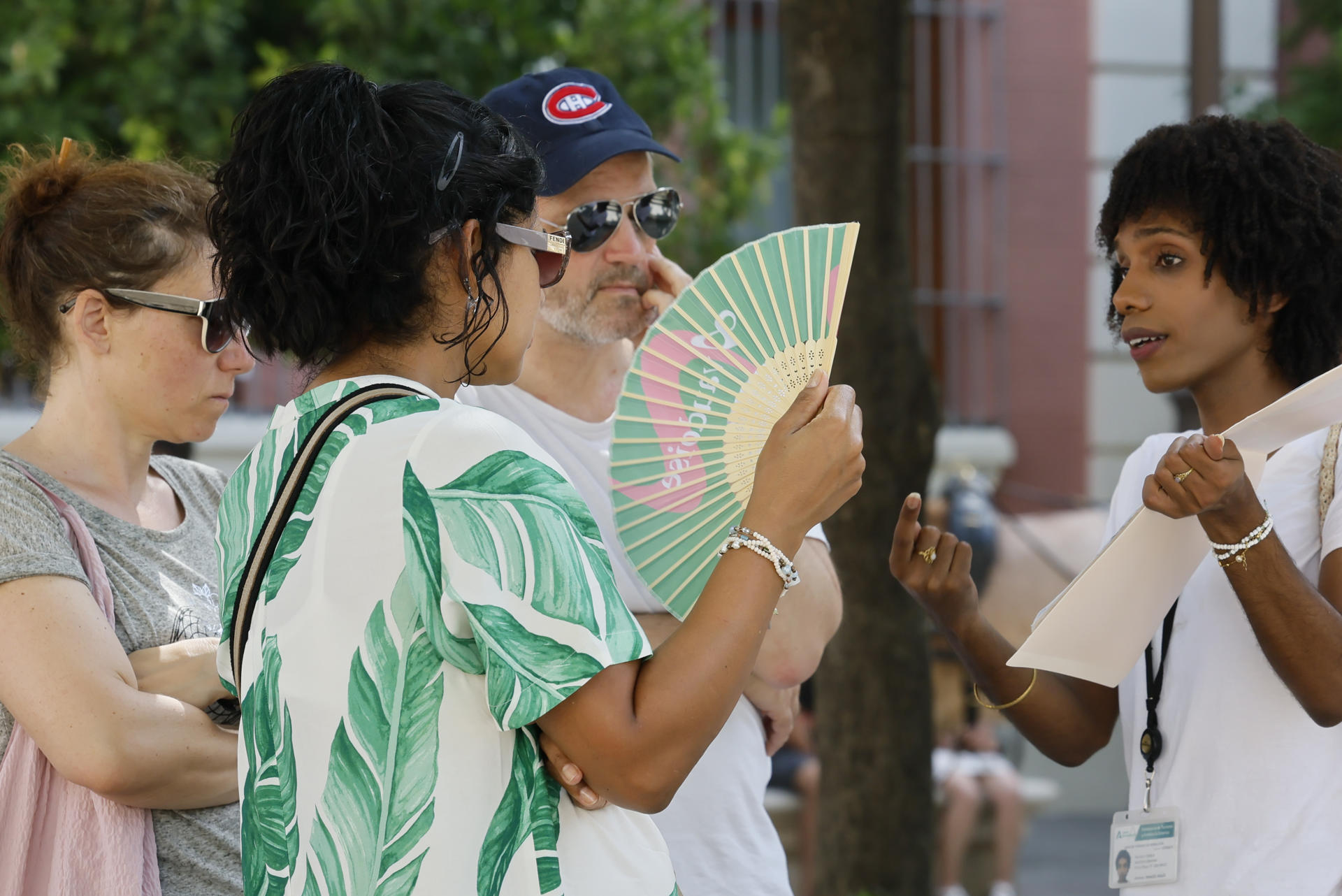 Turistas se refrescan con abanicos mientras caminan por el centro histórico de Sevilla, este martes en el que cinco comunidades de la península se encuentran en nivel de riesgo naranja (importante), con temperaturas de hasta 41 grados en Andalucía.EFE/José Manuel Vidal