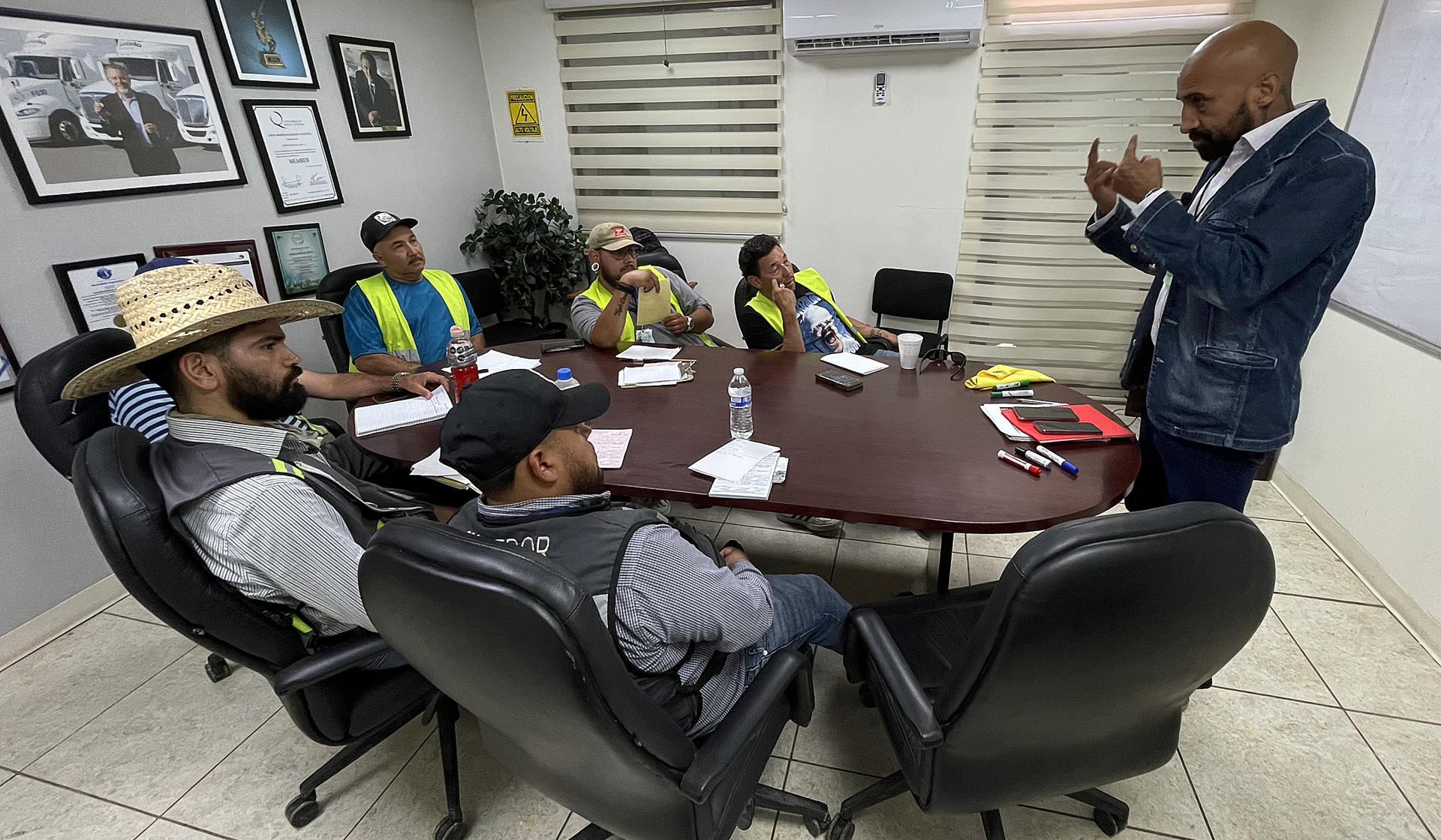 El instructor de la empresa Fletes Sotelo, Ernesto Montes (d), fue captado este sábado, 21 de junio, al impartir una clase de ingles a conductores de la compañía, en Ciudad Juárez (México). EFE/Luis Torres
