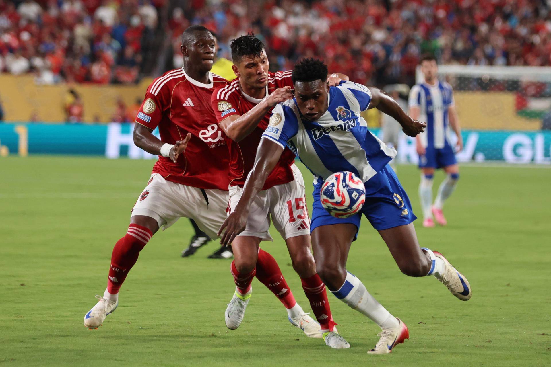 Aliou Dieng (i) y Achraf Dari (c), del Al Ahly disputan un balón ante Samu Aghehowa (d) del Porto en el Mundial de Clubes. EFE/JUSTIN LANE
