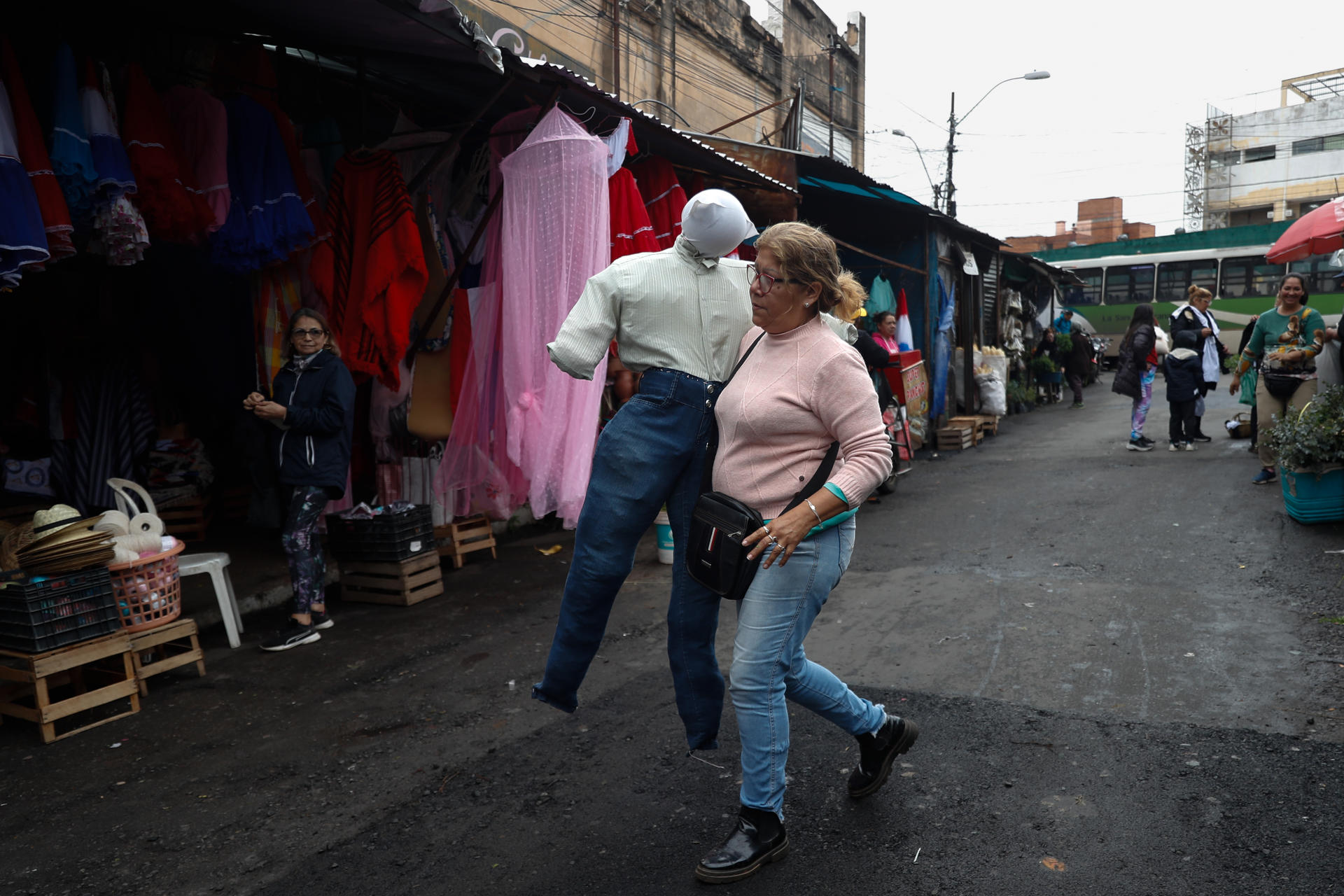 La artesana Carmen Amarilla carga un muñeco 'Judas Kái' este sábado en el Mercado Municipal No. 4 en Asunción (Paraguay). EFE/ Juan Pablo Pino