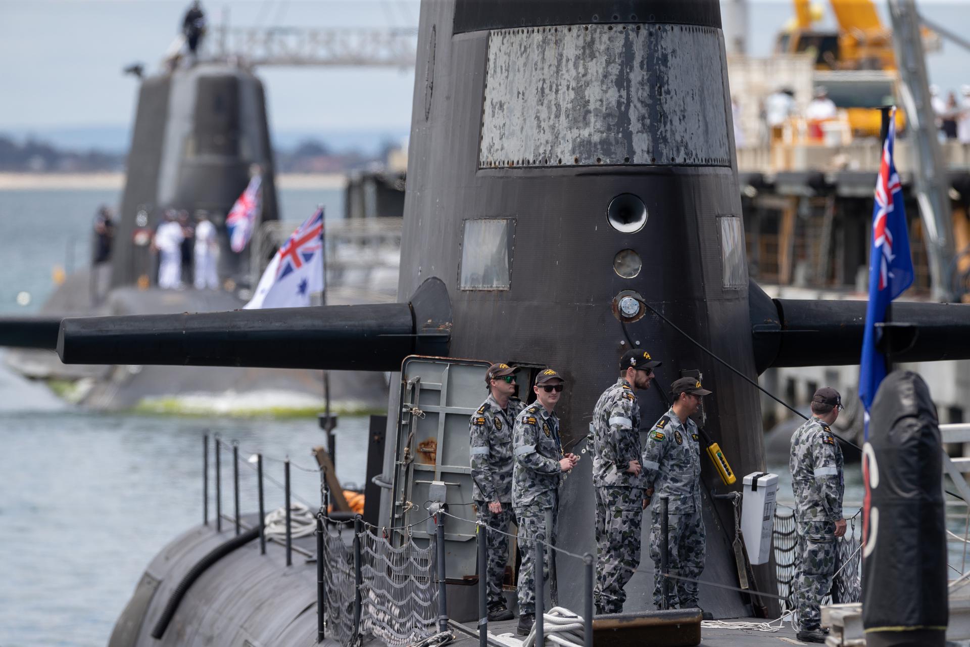 Imagen de archivo tomada del 29 de octubre de 2021 en Perth, Australia, que muestra a miembros de la tripulación del submarino australiano diésel-eléctrico de clase Collins, junto al submarino de propulsión nuclear británico HMS Astute (al fondo). EFE/EPA/RICHARD WAINWRIGHT AUSTRALIA AND NEW ZEALAND OUT[AUSTRALIA AND NEW ZEALAND OUT]
