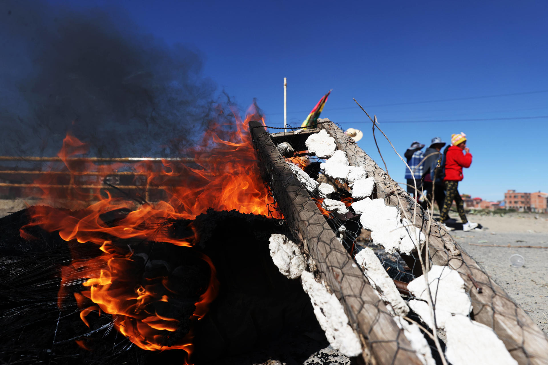 Personas caminan junto a una vía bloqueada durante una protesta este 3 de junio de 2025, en El Alto (Bolivia). EFE/ Luis Gandarillas