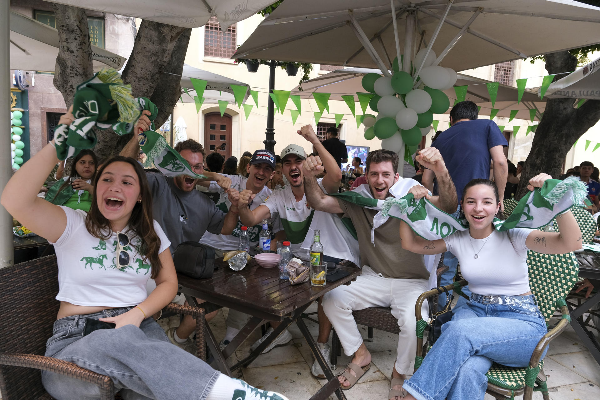 Aficionados del Elche celebran uno de los goles de su equipo en el centro de Elche durante el partido contra el Deportivo, este domingo. EFE /Pablo Miranzo
