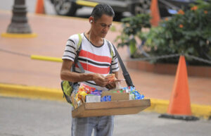 Fotografía de archivo que muestra a un vendedor ambulante que cuenta su dinero en Tegucigalpa (Honduras). EFE/Gustavo Amador