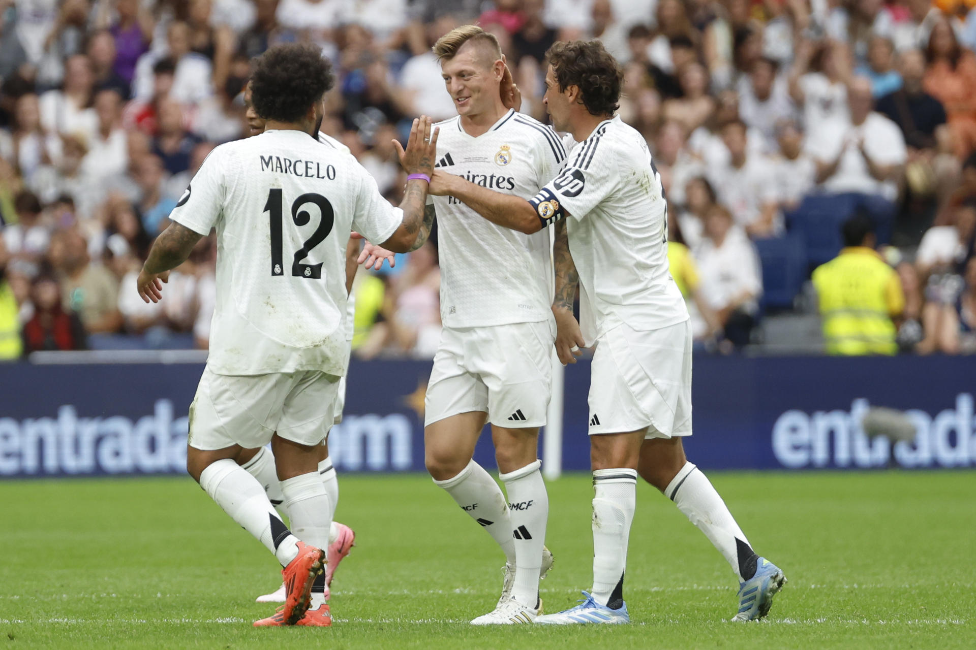El exjugador del Real Madrid Tony Kroos (c) es felicitado por sus compañeros Raúl González Blanco (d) y Marcelo después de marcar un gol en el partido benéfico de leyendas XII Corazón Classic Match Real Madrid-Borussia Dortmund en el Santiago Bernabéu en Madrid. EFE/ Juanjo Martín