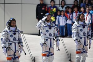 Fotografía de archivo que muestra al comandante de la misión espacial Shenzhou-20, Chen Dong, quien saluda flanqueado por sus compañeros astronautas Chen Zhongrui (d) y Wang Jie (i). EFE/EPA/ANDRES MARTINEZ CASARES