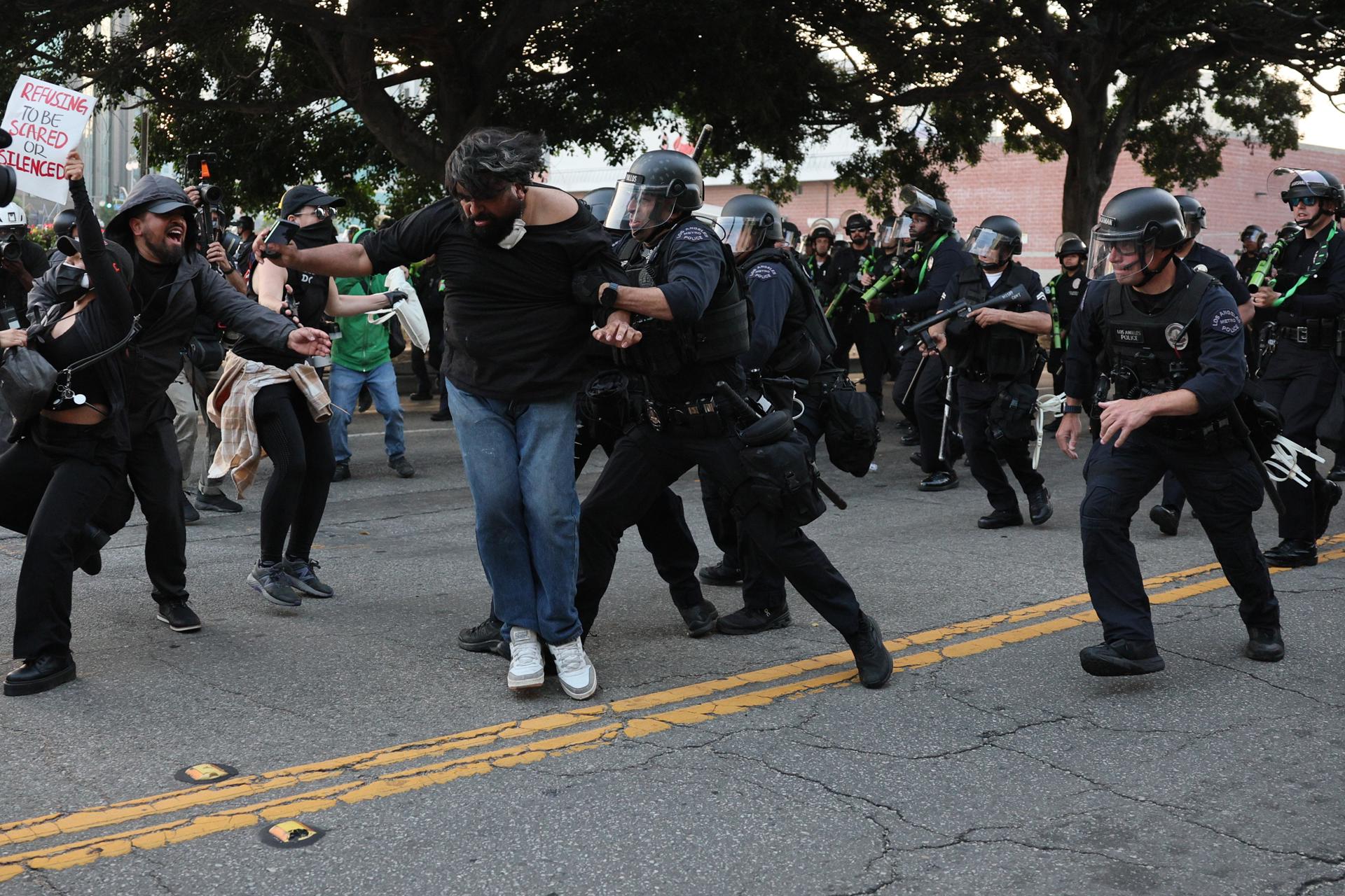 Agentes de la Policía fueron captados este martes, 10 de junio, al detener a un ciudadano, durante las protestas contra las redadas a migrantes presuntamente indocumentados y la presencia de la Guardia Nacional, en Los Ángeles (CA, EE.UU.). EFE/Allison Dinner