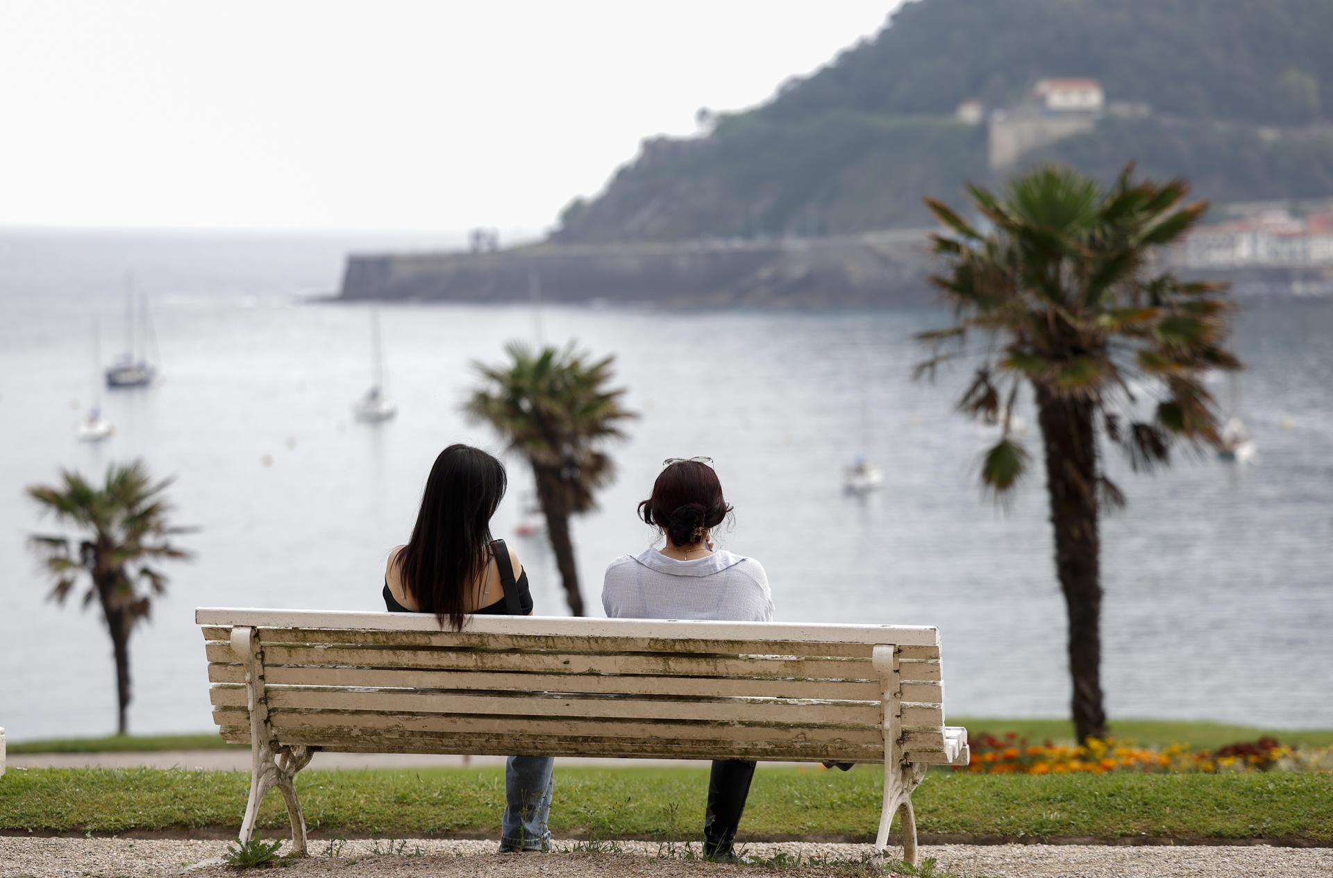 Unas mujeres observan la playa de la Concha desde el palacio de Miramar de San Sebastián. EFE/Juan Herrero.