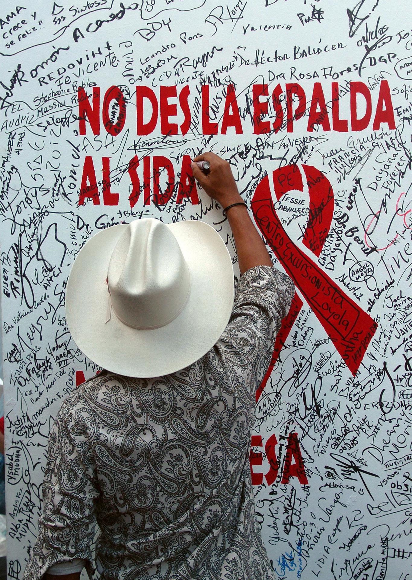 Fotografía de archivo de un joven firmando un mural de compromiso contra el VIH/Sida, durante una reunión de varias organizaciones con motivo del Día Mundial del Sida, en Santo Domingo (República Dominicana). EFE/Orlando Barría/ARCHIVO