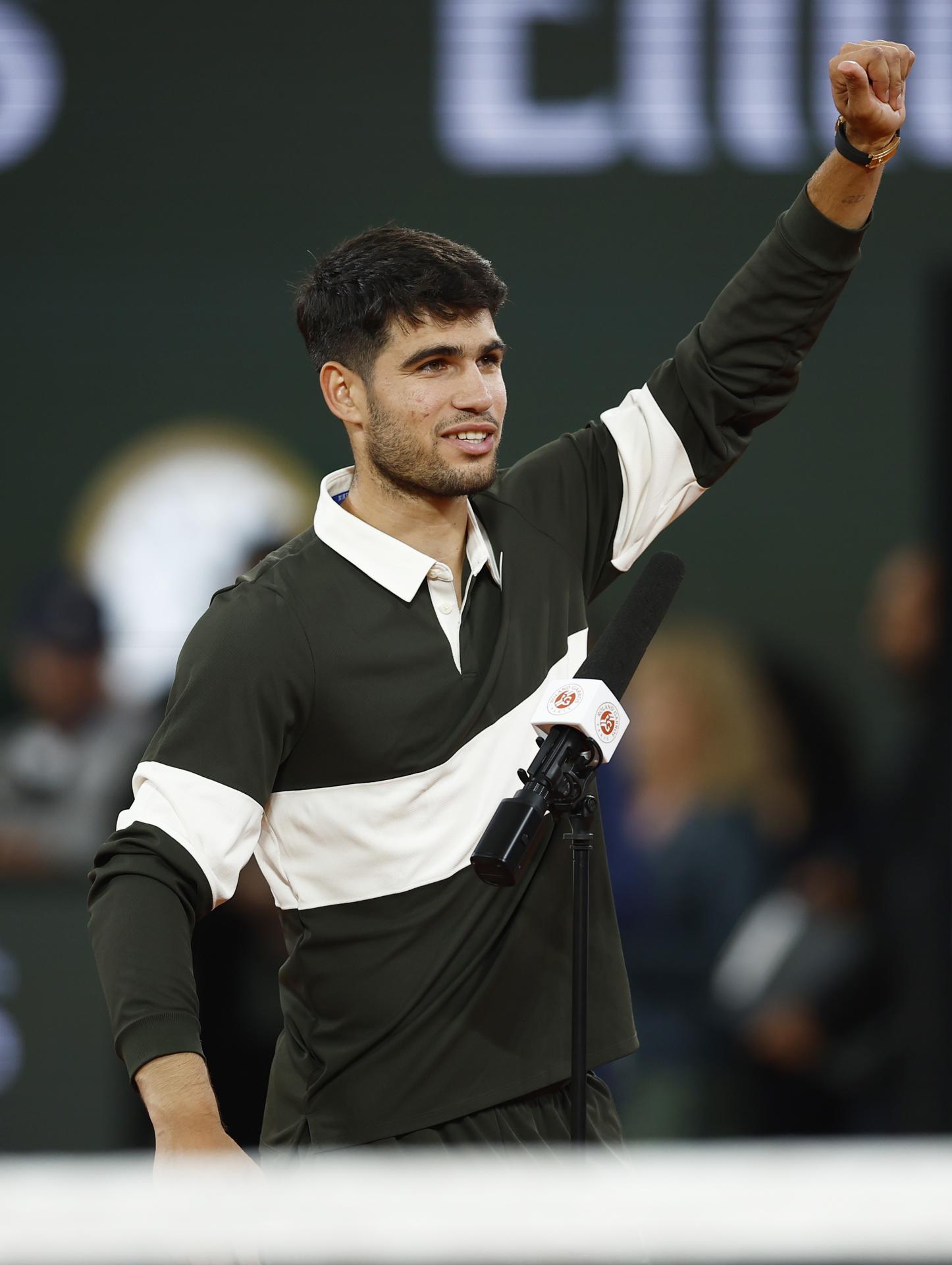 El tenista español Carlos Alcaraz saluda este viernes, tras su victoria en las semifinales de Roland Garros frente al italiano Lorenzo Musetti. EFE/YOAN VALAT