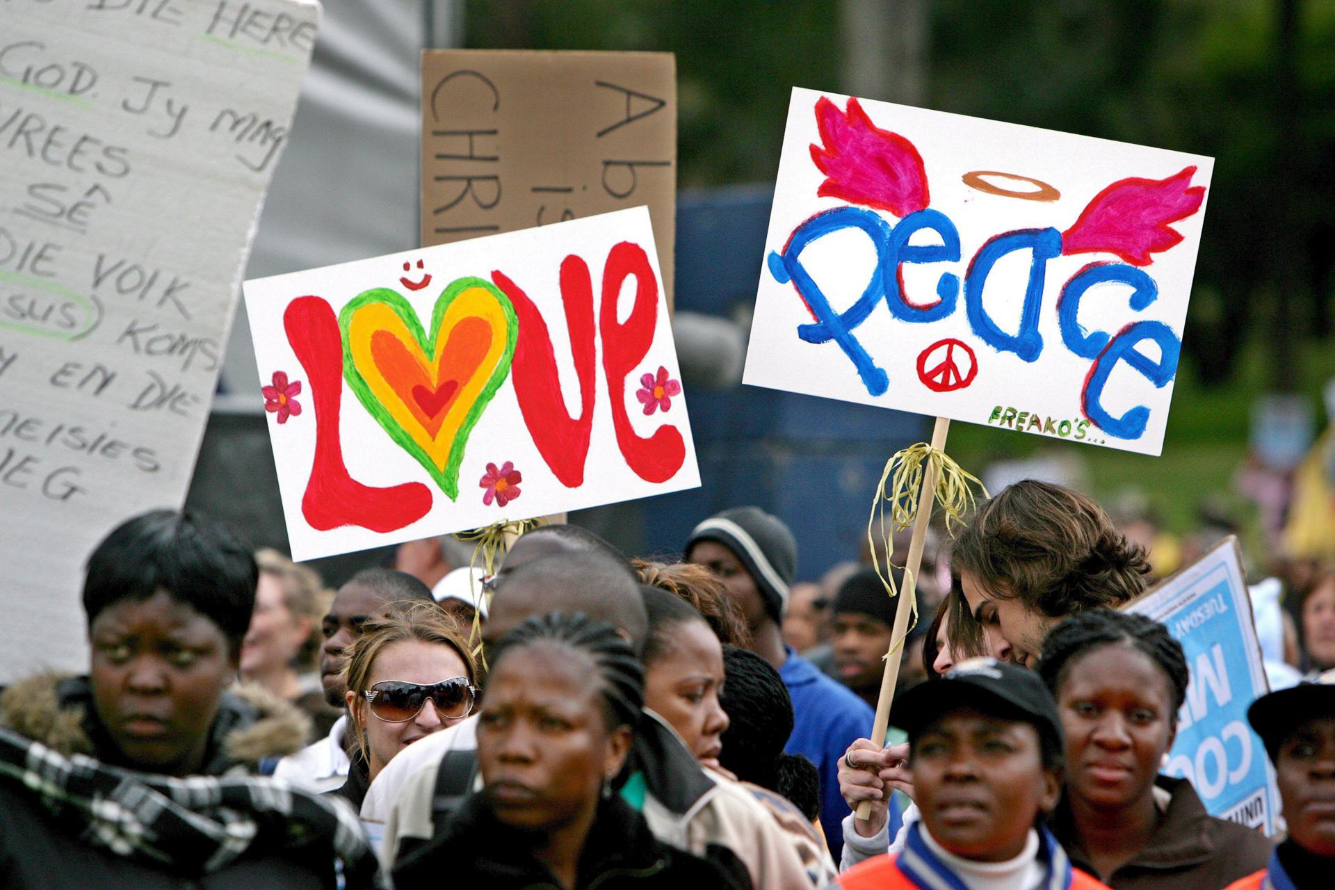 Manifestantes con carteles en los que se lee "amor" y "paz" durante la marcha en Pretoria que pretende la restauración de la pena de muerte en el país. EFE/Archivo/Jon Hrusa.