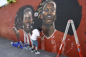 El artista Carlos López ha comenzado este viernes la restauración del mural que pintó en Barakaldo en marzo de 2024 en homenaje a los hermanos Williams y que sufrió un acto vandálico hace escasos días tras conocerse el posible fichaje de Nico por el Barcelona. EFE/ Miguel Toña
