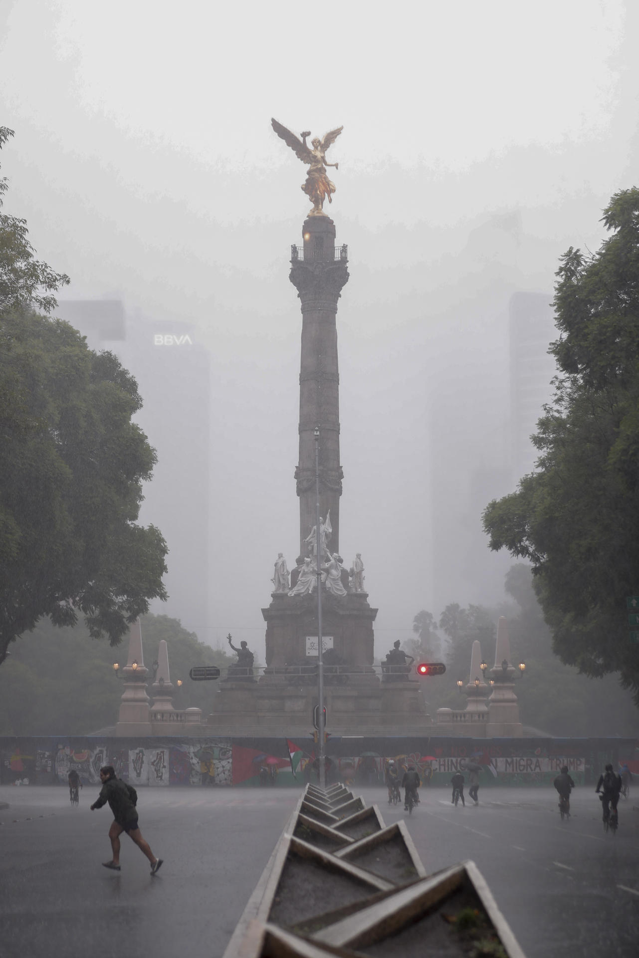 Personas permanecen bajo la lluvia este domingo, en Ciudad en México (México). EFE/ Isaac Esquivel
