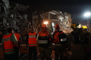 Fotografía cedida por las Fuerzas de Defensa de Israel (FDI) donde se observa a integrantes de los cuerpos de emergencia junto a un edificio destruido por un misil iraní este sábado, en Tel Aviv (Israel). EFE/ Fuerzas de Defensa de Israel