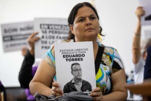 Foto de archivo de Emiselys Núñez, que sostiene un cartel de su esposo detenido, el activista y abogado, Eduardo Torres. EFE/ Ronald Pena R