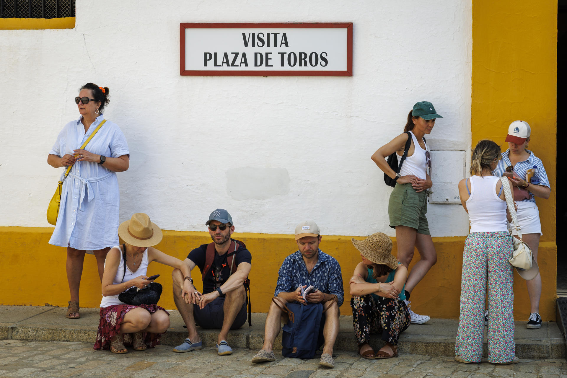 Unos turistas descansaban este sábado a la sombra en la entrada de la Plaza de Toros de la Maestranza de Sevilla. EFE/ Julio Muñoz