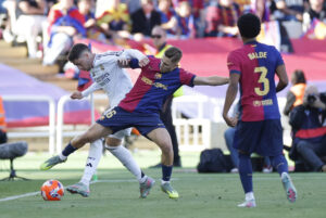 El centrocampista del FC Barcelona, Fermín López (d), disputa el balón ante el centrocampista uruguayo del Real Madrid, Federico Valverde, durante un partido de LaLiga EA Sports. EFE / Alberto Estevez.