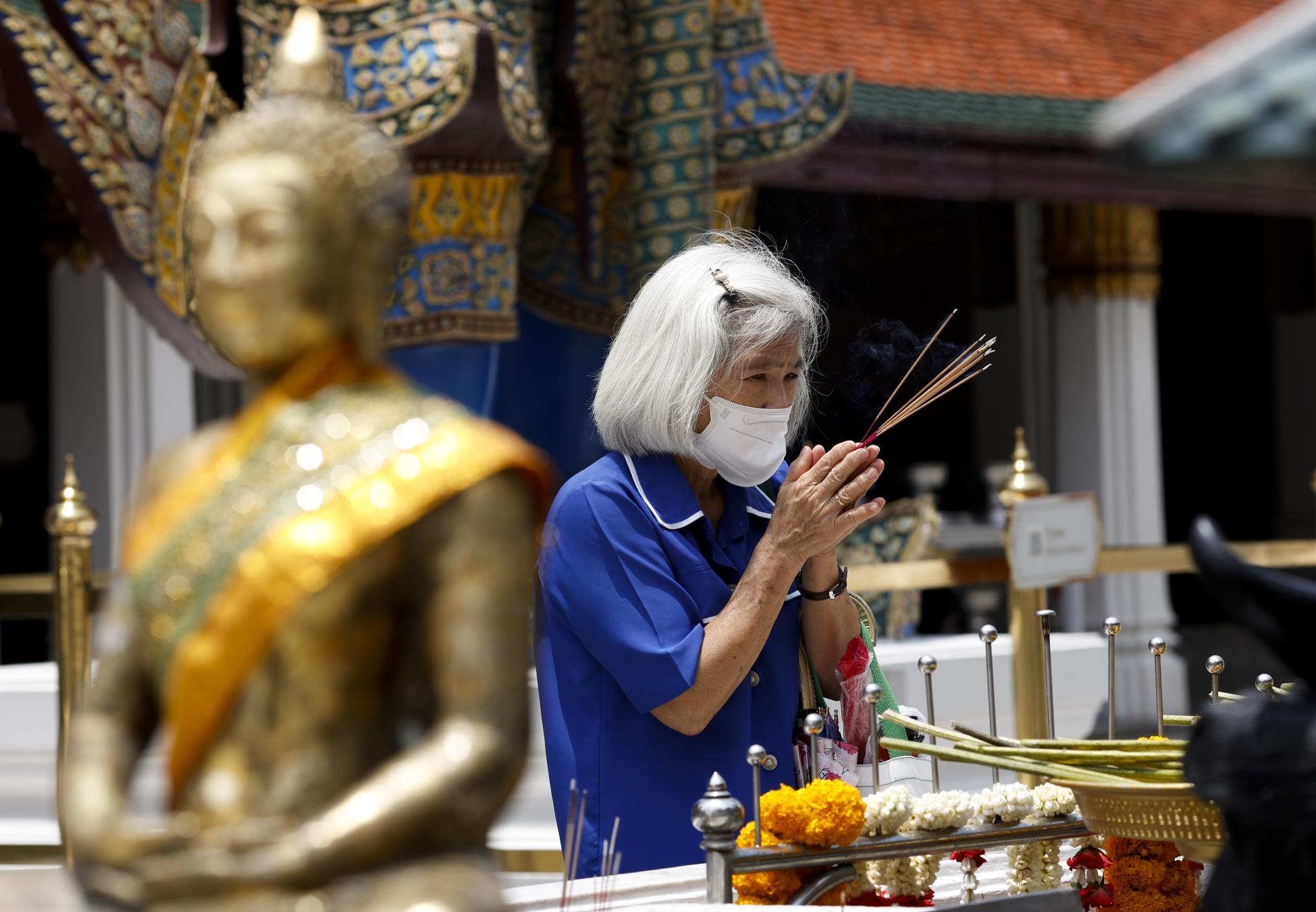 Fotografía de archivo, tomada el 28/05/2025, que muestra a una mujer usando mascarilla durante una visita a un sitio budista en Bangkok, Tailandia. EFE/EPA/RUNGROJ YONGRIT