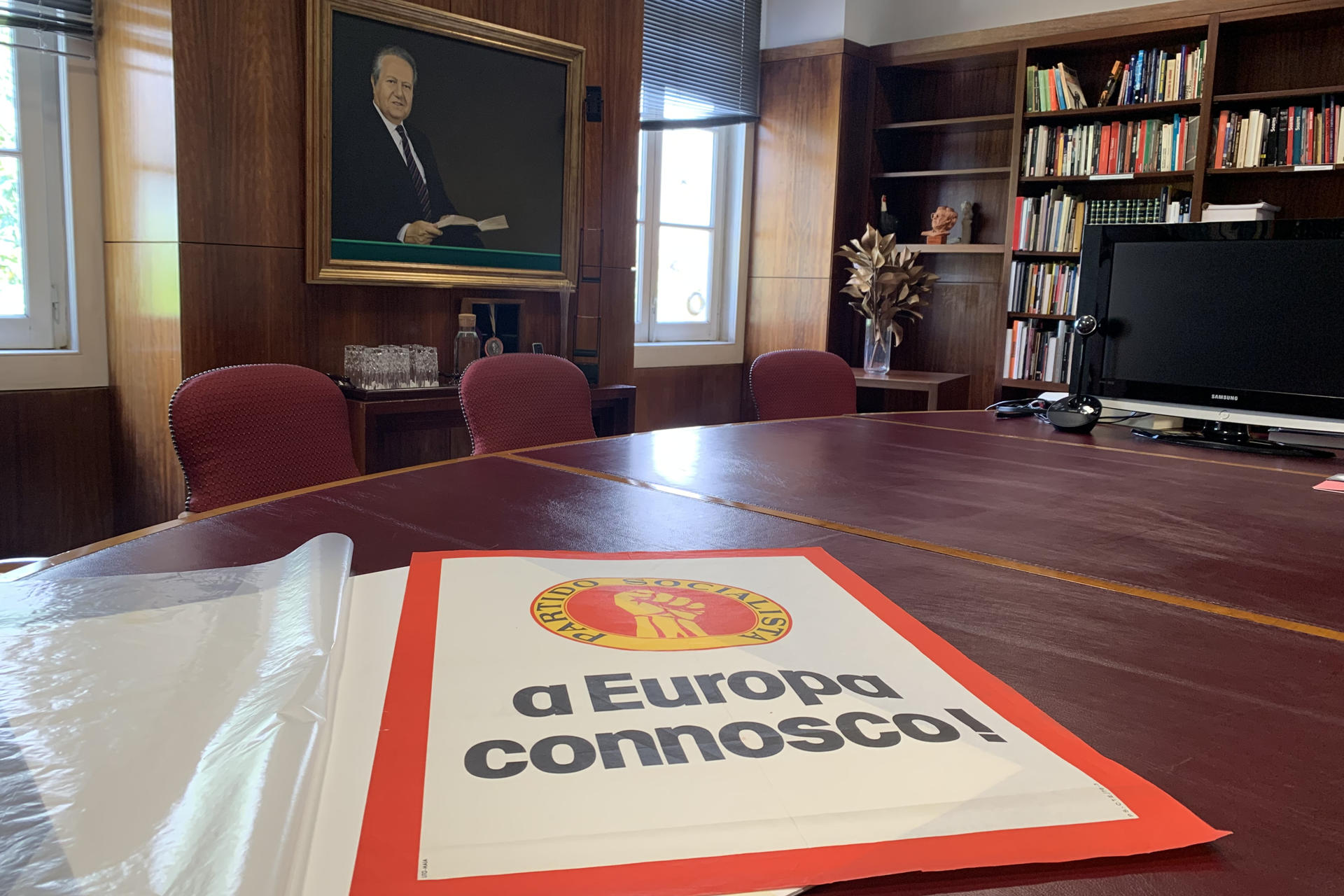 Cartel del Partido Socialista del siglo XX en el que defendían la adhesión de Portugal a la CEE ante un retrato de Mário Soares expuestos en la Fundación Mário Soares e Maria Barroso de Lisboa. EFE/ Carlota Ciudad