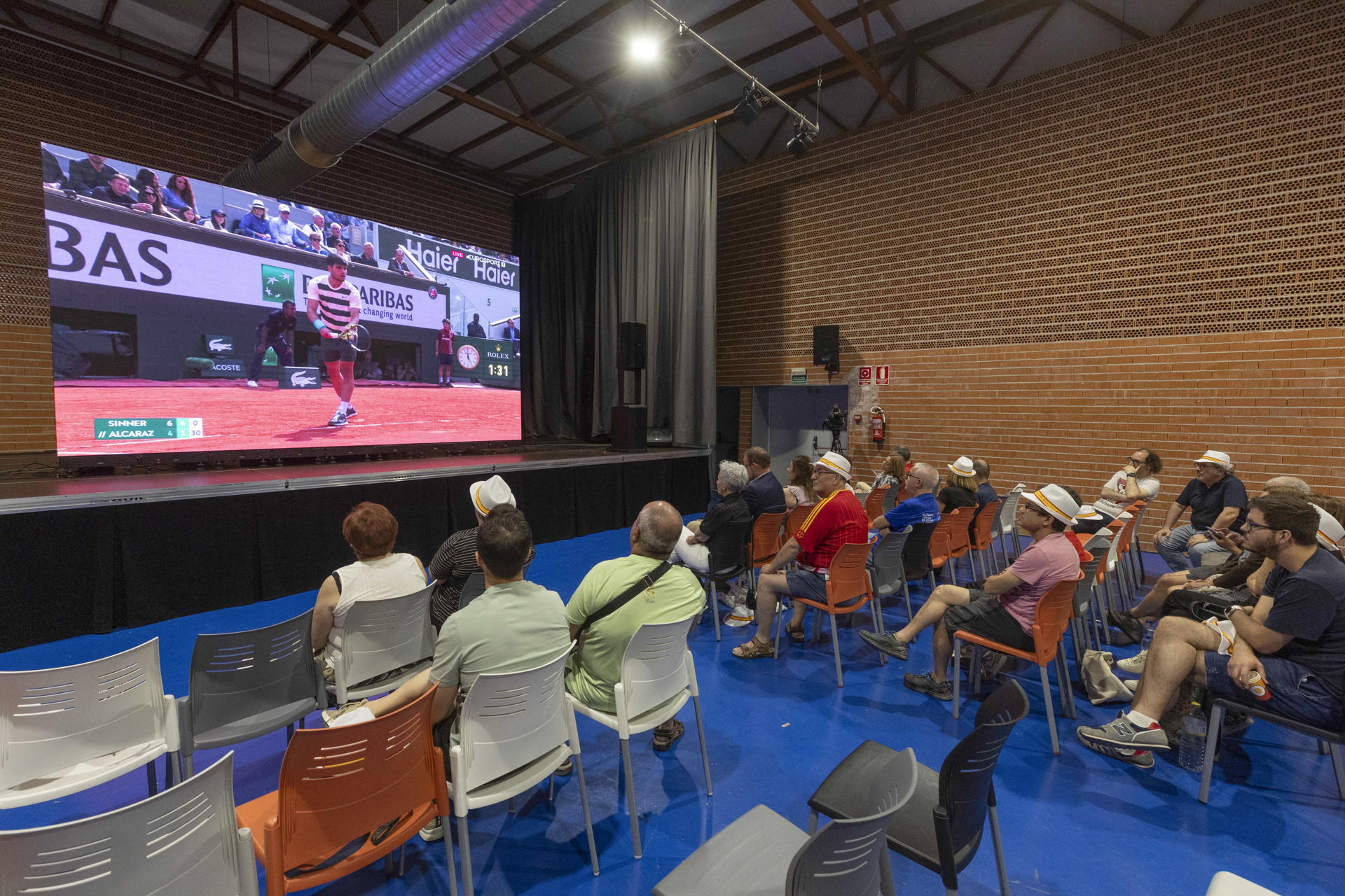 Vecinos de Carlos Alcaraz de la pedanía murciana de El Palmar ven la segunda final de Roland Garros consecutiva que juega el tenista murciano, este domingo en una pantalla gigante instalada por el Ayuntamiento de Murcia en el pabellón de El Palmar. EFE/Marcial Guillén
