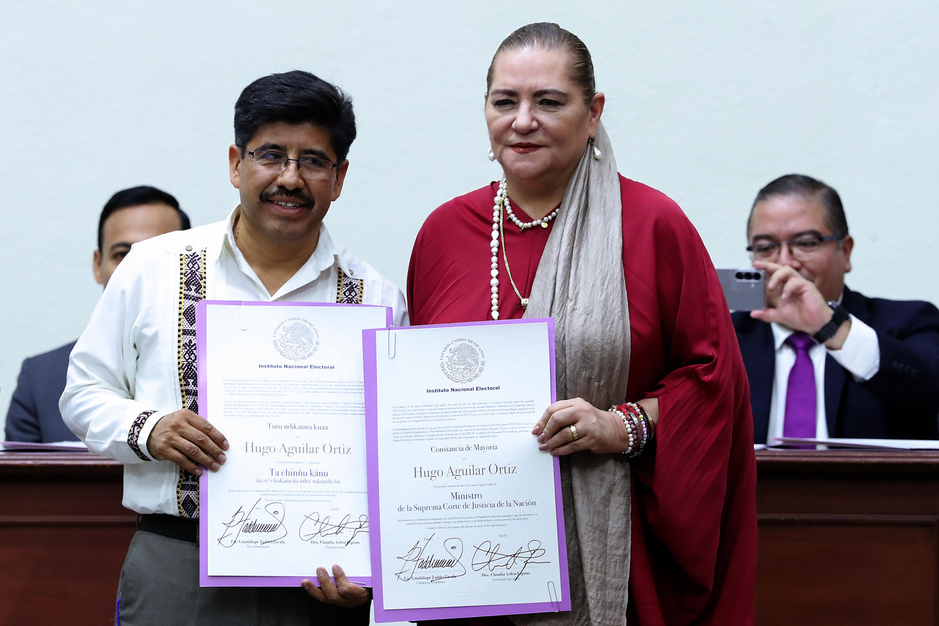 La presidenta del Consejo General del Instituto Nacional Electoral (INE) Guadalupe Taddei Zavala (d), entrega a Hugo Aguilar (i) su constancia de mayoría a presidente ministro electo de la Suprema Corte de Justicia de la Nación (SCJN), este domingo en Ciudad de México (México). EFE/ Mario Guzmán