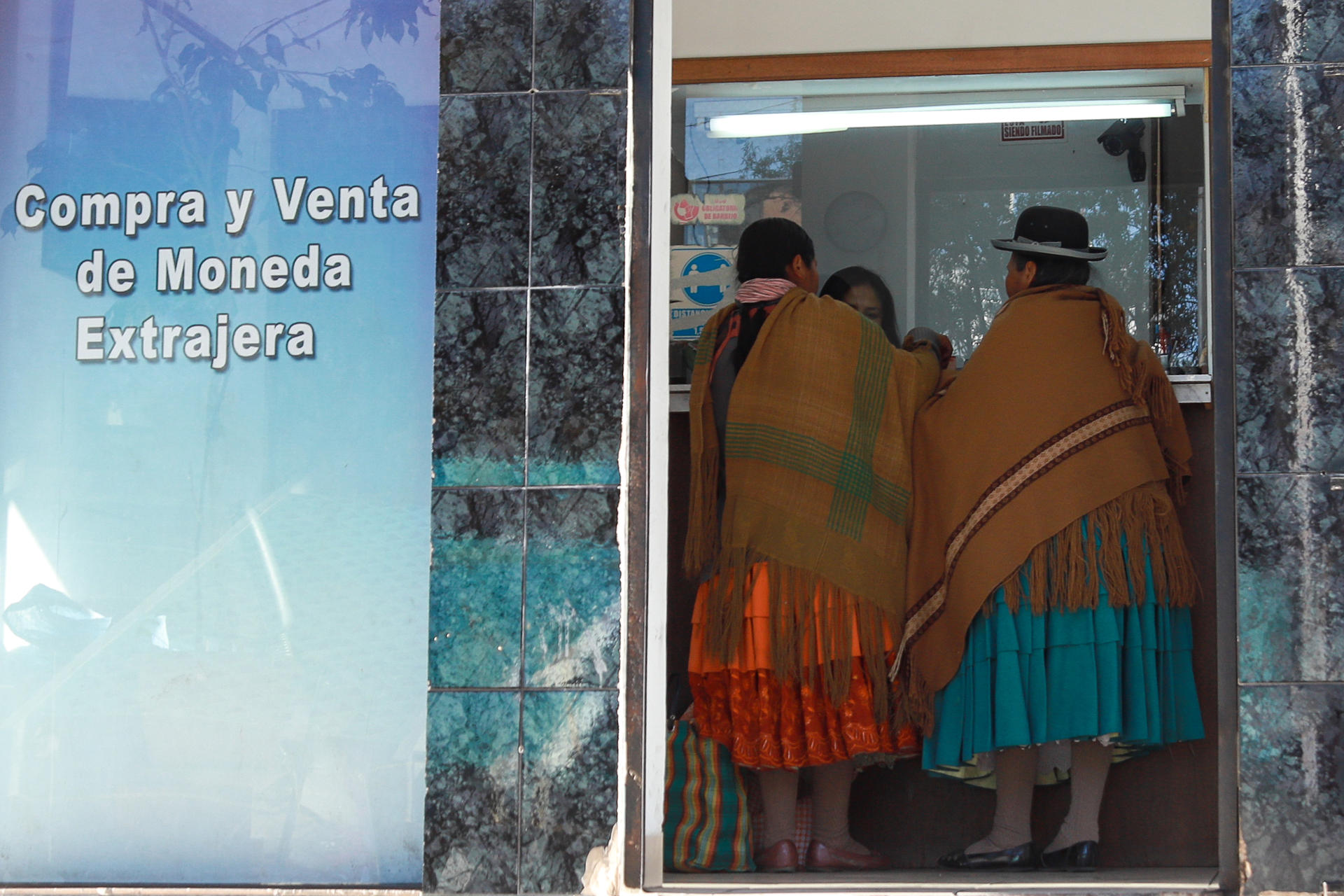 Mujeres aimaras entran a una casa de cambio este jueves, en el centro de La Paz (Bolivia). EFE/ Gabriel Márquez