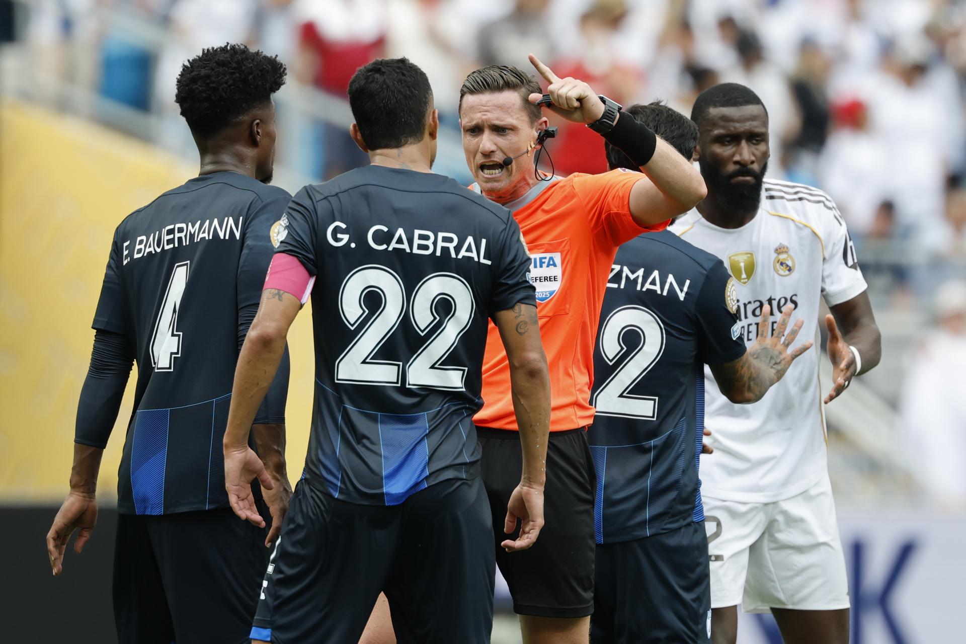 Eduardo Bauermann y Gustavo Cabral, capitán del Pachuca, alegan con el árbitro brasileño Ramon Abatti durante el partido ante el Real Madrid. EFE/EPA/ERIK S. LESSER