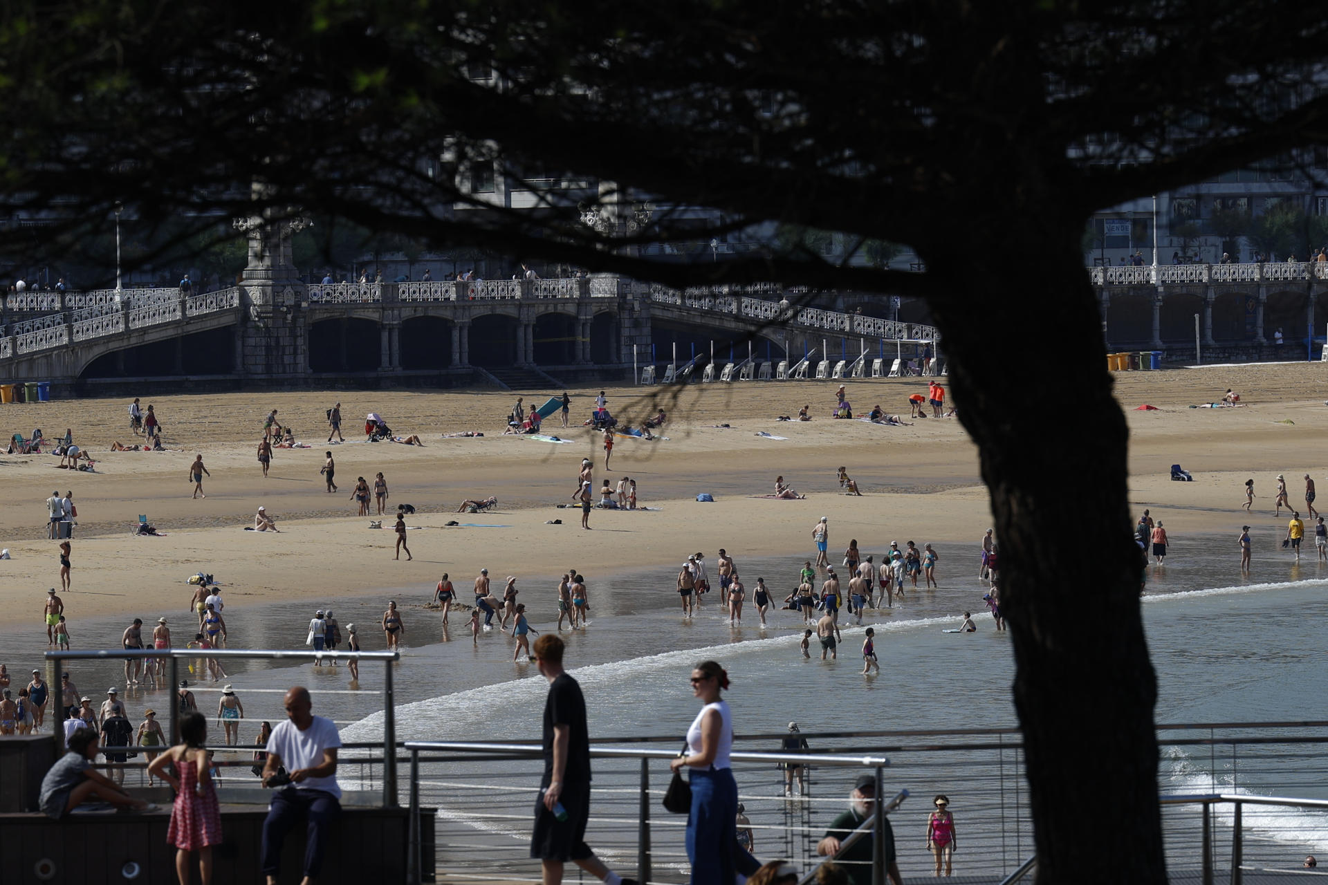 Turistas y donostiarras disfrutan de un día soleado en la playa de la Concha de San Sebastián. Los cielos del País Vasco se presentan este martes parcialmente nubosos, la nubosidad aumentará por la tarde, cuando podrán caer tormentas, las temperaturas ascenderán ligera a moderadamente y el viento soplará flojo variable, con rachas fuertes en las zonas de tormenta por la tarde. EFE/Juan Herrero.