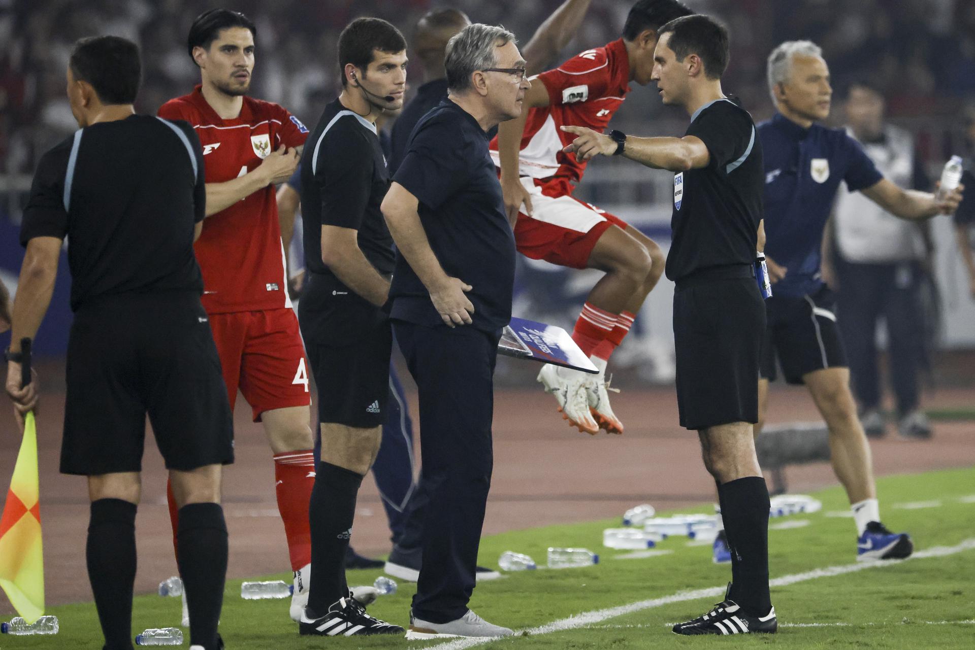El árbitro Rustam Lutfullin se dirige al seleccionador de China Branko Ivankovic durante el partido ante Indonesia de este jueves. EFE/EPA/BAGUS INDAHONO