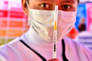 Una persona alista una jeringa con una dosis de vacuna contra el sarampión en Bolivia. EFE/Jorge Ábrego