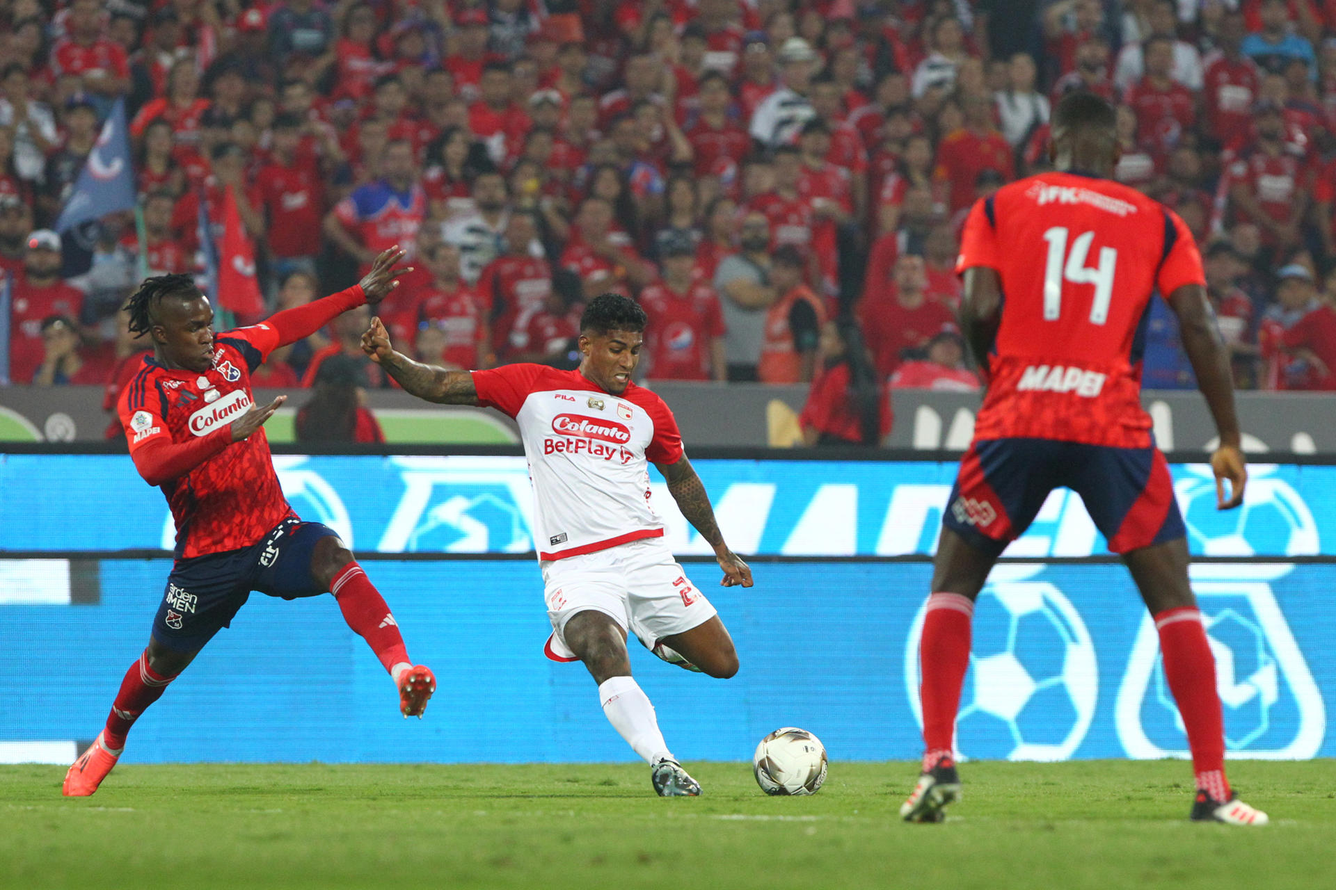 José Ortiz (i), de Medellín, disputa el balón con Harold Santiago Mosquera (c), de Santa Fe, durante el partido de vuelta de la final del la liga colombiana entre Deportivo Independiente Medellín e Independiente Santa Fe en el estadio Atanasio Girardot en Medellín (Colombia). EFE/ STR