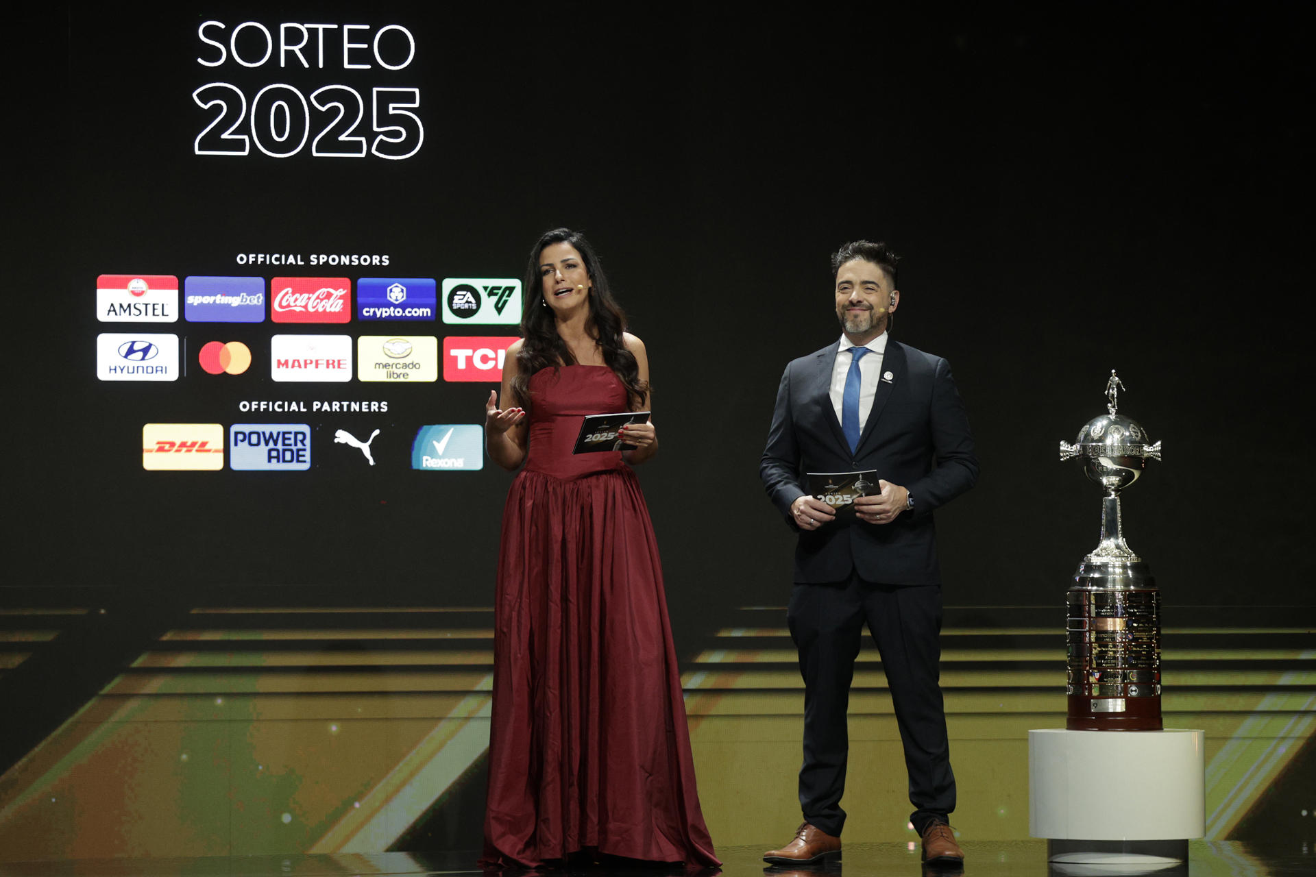 Los presentadores Helena Calil (i) y Juan José Buscalia hablan durante el sorteo de los octavos de final de la Copa Libertadores 2025. EFE/Juan Pablo Pino
