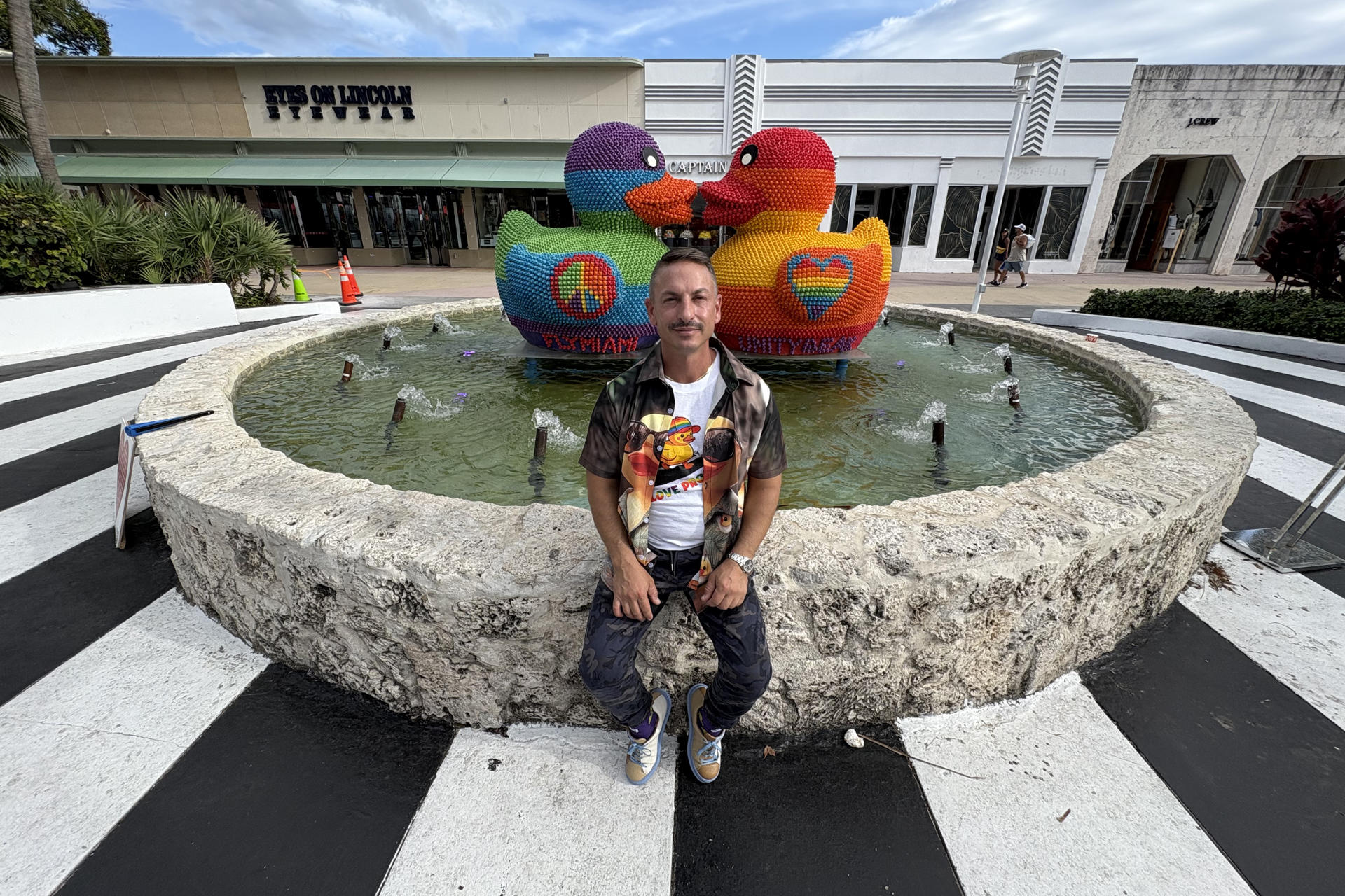 El artista argentino Facundo L. Yebne, cuyo nombre artístico es FLY, posa junto a su obra 'UnityBeak' este miércoles, en Miami Beach (Estados Unidos). EFE/Albert Boal