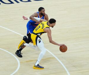 Tyrese Haliburton, de los Pacers, intenta avanzar ante la marca de Mikal Bridges, de los Knicks. EFE/EPA/BRIAN SPURLOCK