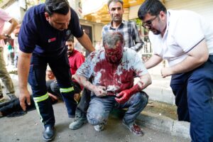 Personas ayudan a un hombre herido tras un ataque aéreo israelí en el centro de Teherán. EFE/Amir KIholousi