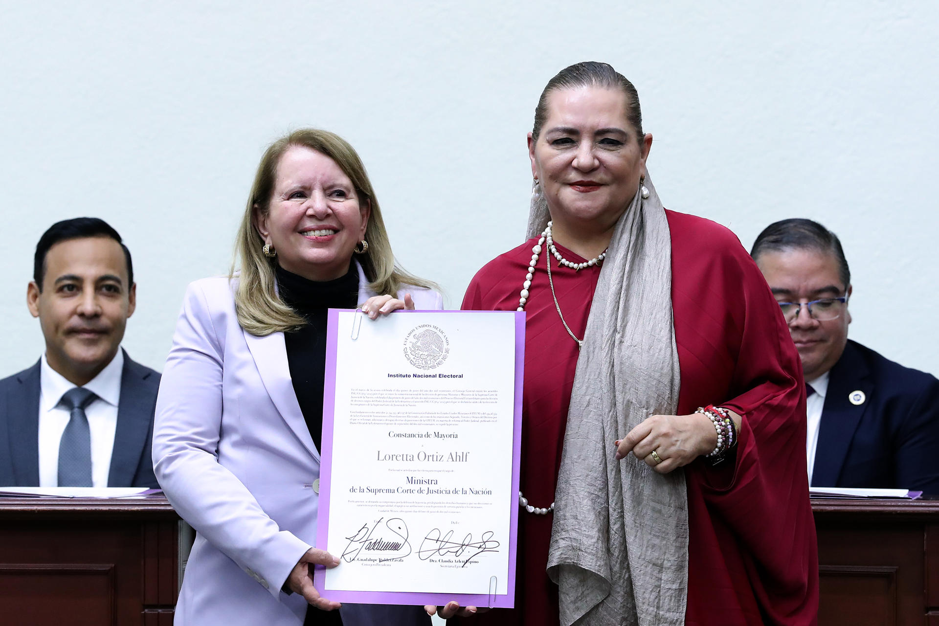 La presidenta del Consejo General del Instituto Nacional Electoral (INE) Guadalupe Taddei Zavala (d), entrega a Loretta Ortiz (i) su constancia de mayoría a ministra electa de la Suprema Corte de Justicia de la Nación (SCJN), este domingo en Ciudad de México (México). EFE/ Mario Guzmán