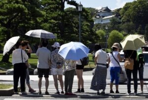 Varias personas se protegen del sol mientras pasean por los jardines del Palacio Imperial en Tokio, en una fotografía de archivo. EFE/FRANCK ROBICHON
