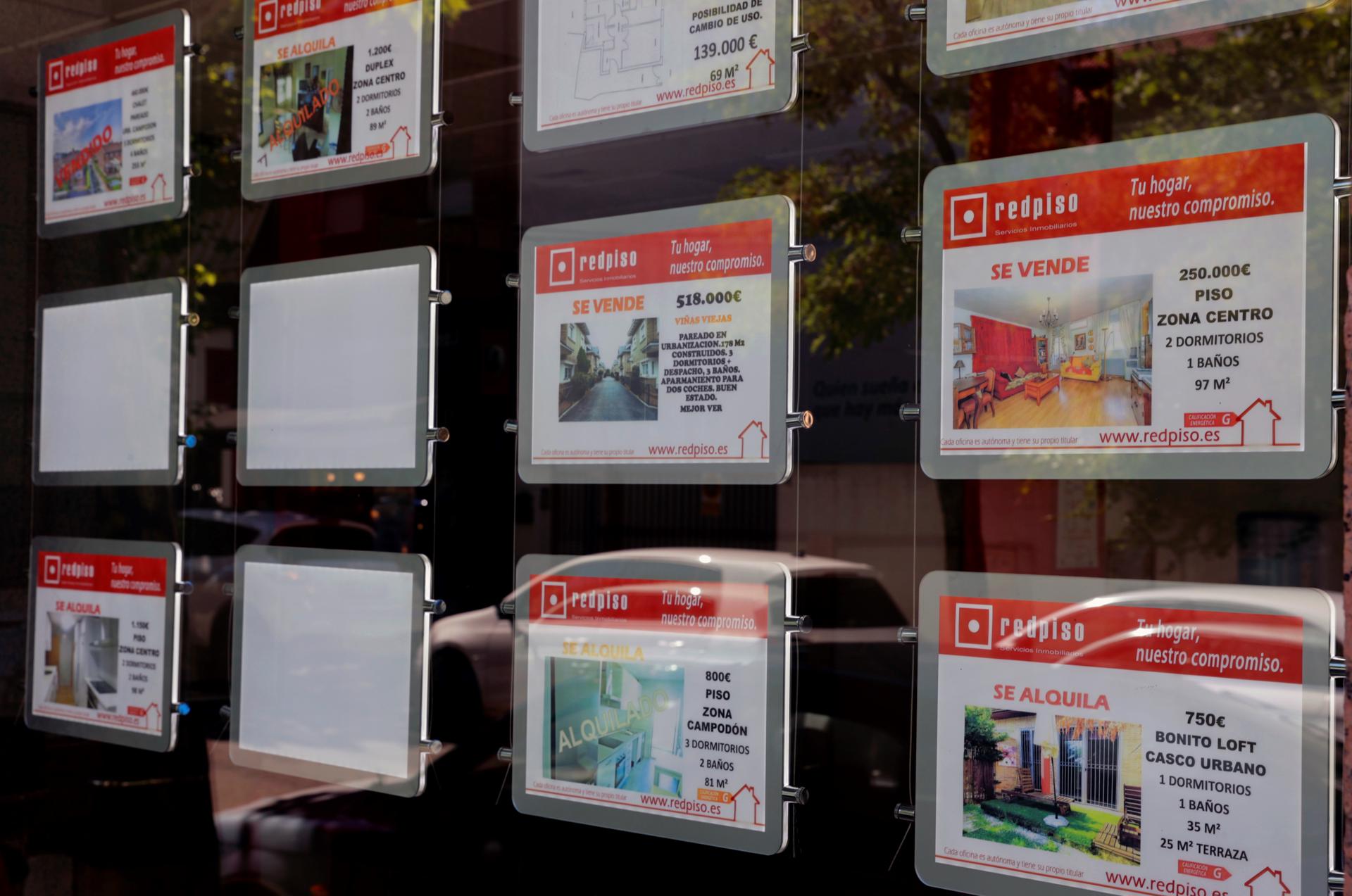 Anuncios de pisos y casas en venta y alquiler en el escaparate de una inmobiliaria en Madrid. EFE/Zipi