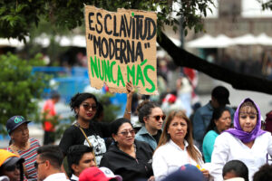 Una mujer fue captada este sábado, 31 de mayo, al sostener un cartel que exige el fin de la esclavitud moderna, durante un acto en el que el Gobierno ecuatoriano pidió disculpas a las víctimas de esclavitud moderna cometida por la empresa de capitales japoneses Furukawa, frente el Palacio de Gobierno, en Quito (Ecuador). EFE/José Jácome