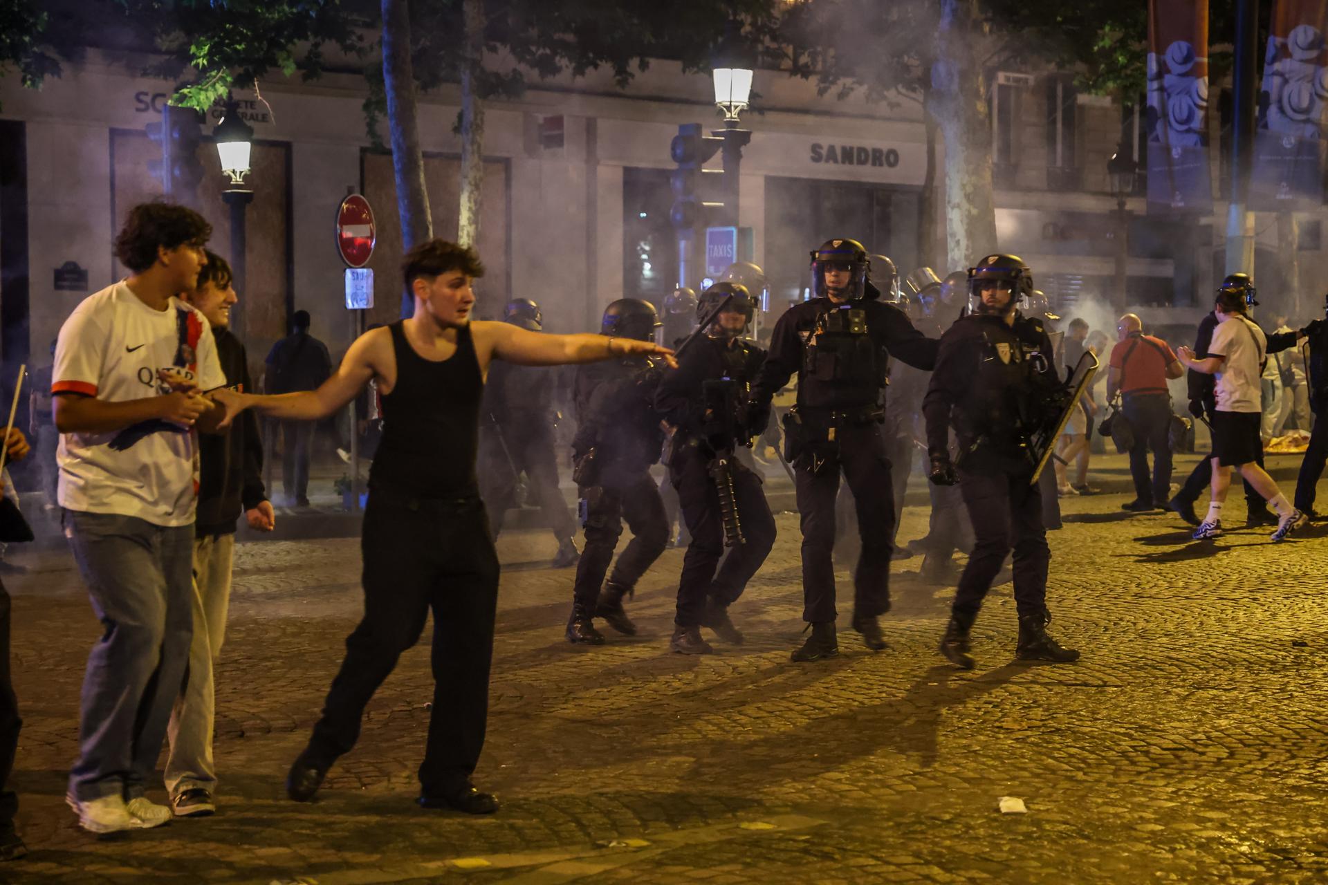 French police in action as clashes erupt with PSG fans celebrating on the Champs-Elysees after their team won the UEFA Champions League final between Paris Saint-Germain and Internazionale Milano, Paris, France, 31 May 2025. (Liga de Campeones, Francia) EFE/EPA/CHRISTOPHE PETIT TESSON