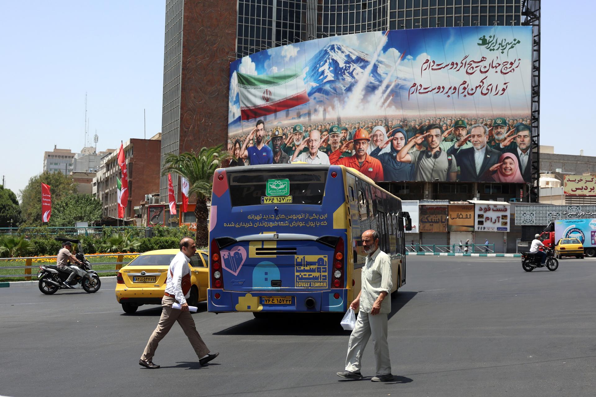 Peatones caminan por una calle cerca de una valla publicitaria que muestra a varios iraníes, incluido personal militar y el ministro de Asuntos Exteriores iraní, Abbas Araghchi (3-D), saludando y un mensaje que dice "Todos somos soldados de Irán" en la plaza Vali-Asr de Teherán, Irán, este 22 de junio de 2025. EFE/EPA/ABEDIN TAHERKENAREH
//////////
Tehran (Iran (Islamic Republic Of)), 22/06/2025.- Pedestrians walk along a street near a billboard showing various Iranians including military personnel and Iranian Foreign Minister Abbas Araghchi (3-R) saluting and a message reading 'We all are soldiers of Iran' at Vali-Asr square in Tehran, Iran, 22 June 2025. The US forces struck three of Iran's key nuclear sites: Natanz, Isfahan and Fordo, US President Trump announced on 21 June. Israel and Iran have been exchanging fire since Israel launched strikes across Iran on 13 June 2025 as part of Operation 'Rising Lion.' (Teherán) EFE/EPA/ABEDIN TAHERKENAREH