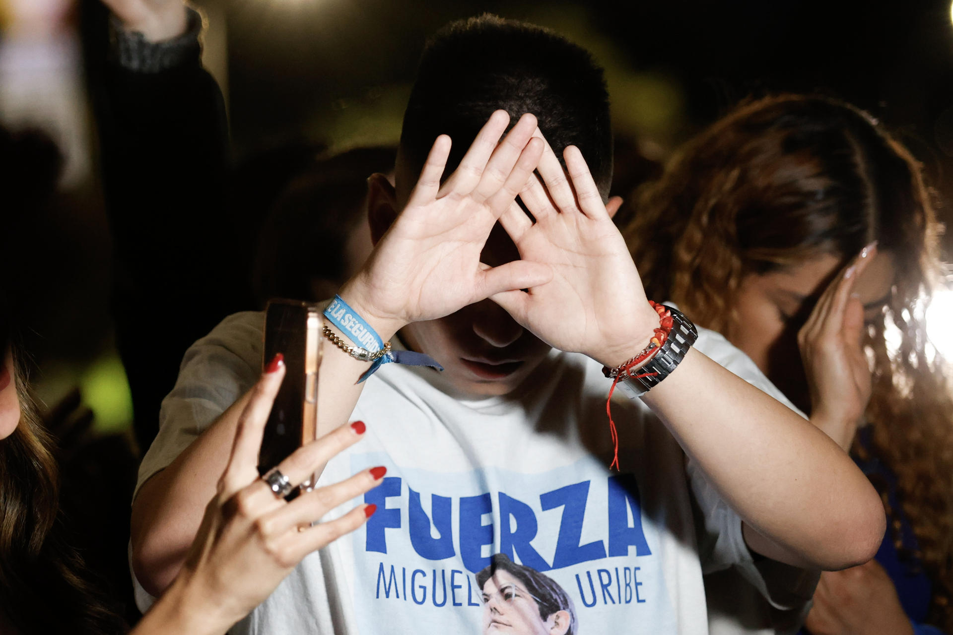 Un joven fue captado al rezar por la salud del senador y precandidato presidencial colombiano Miguel Uribe Turbay, frente a la entrada de la Fundación Santa Fe, donde el político permanece recluido luego de ser tiroteado el pasado 7 de junio, en Bogotá (Colombia). EFE/Mauricio Dueñas