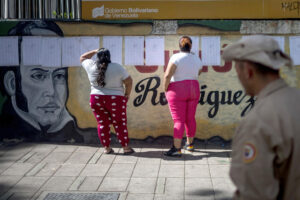 Fotografía del 25 de mayo de 2025 de dos personas buscando su mesa asignada en un puesto de votación, en Caracas (Venezuela). EFE/ Miguel Gutiérrez