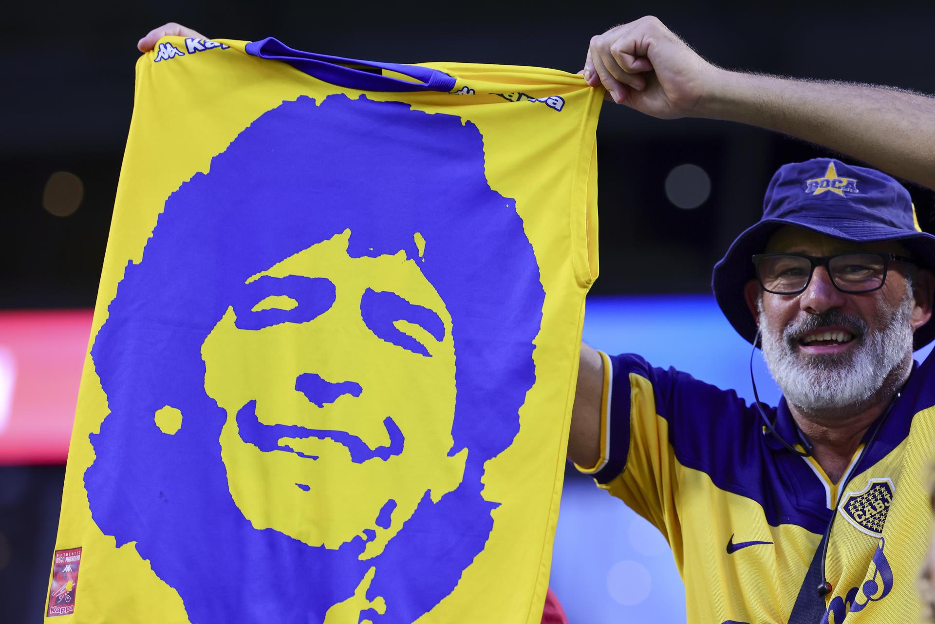 Un hincha de Boca Juniors sostiene una camiseta con el rostro del ídolo argentino Diego Maradona en el juego en Miami ante el Bayern Múnich. EFE/EPA/CRISTOBAL HERRERA-ULASHKEVICH